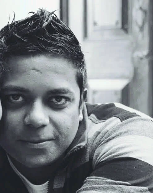 Black-and-white close portrait of Dholi Baba with short, styled hair